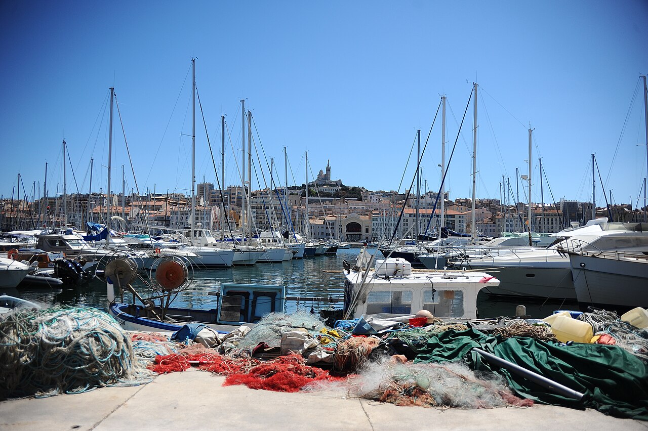 Filets de pêche sur le quai du Vieux-Port, voiliers amarrés et, au loin, Notre-Dame de la Garde au-dessus du quai de Rive-Neuve