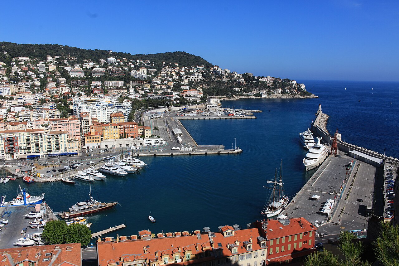 Le port Lympia vu de la colline du Château : bassins, voiliers et yachts, quais, et le mont Boron qui plonge dans la mer