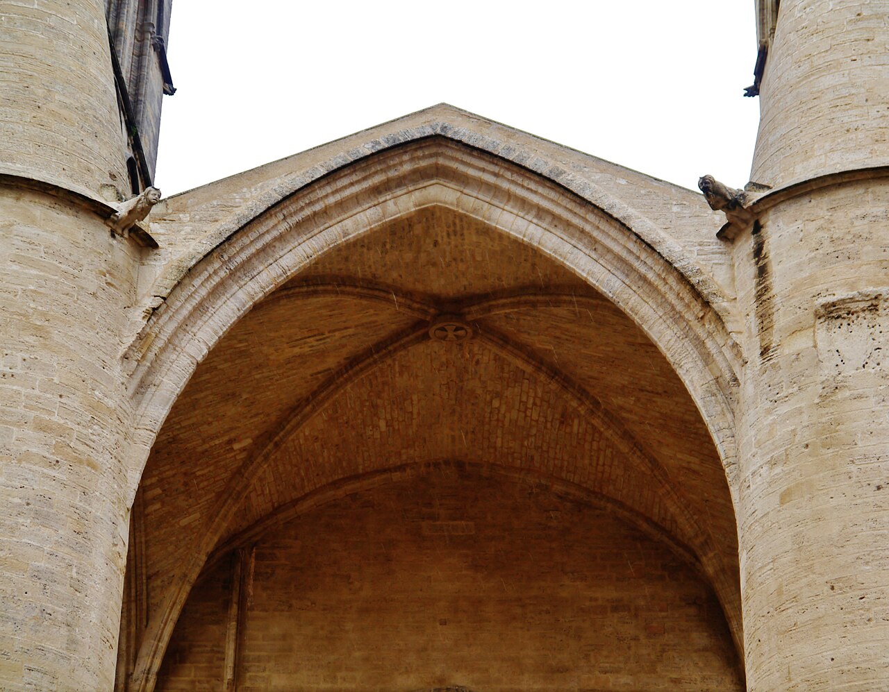 La voûte gothique du porche de la cathédrale Saint-Pierre de Montpellier, entre ses deux grands piliers cylindriques en pierre ornés de gargouilles