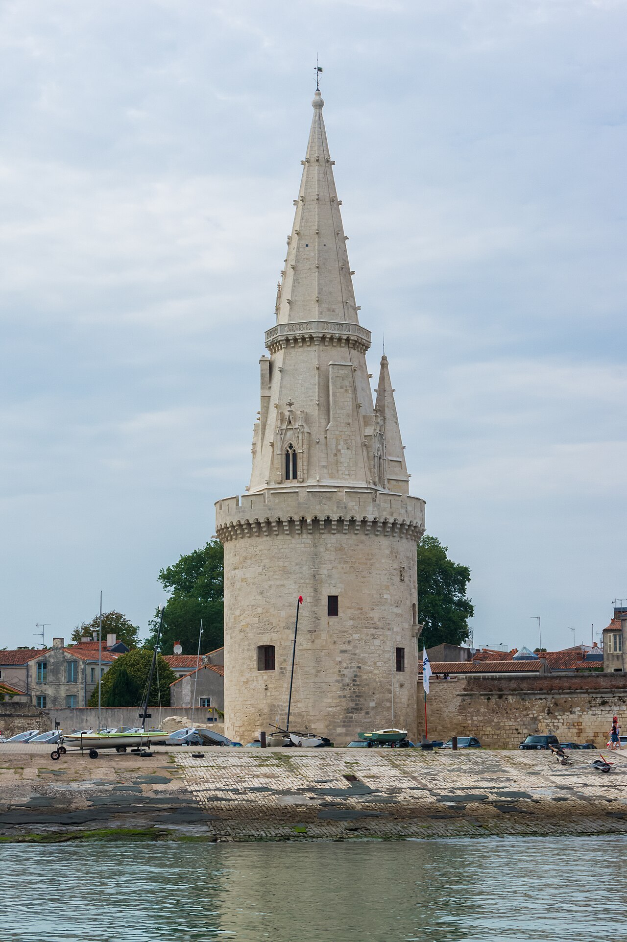 La tour de la Lanterne à La Rochelle, tour ronde à mâchicoulis surmontée d’une haute flèche gothique de pierre, vue depuis le chenal