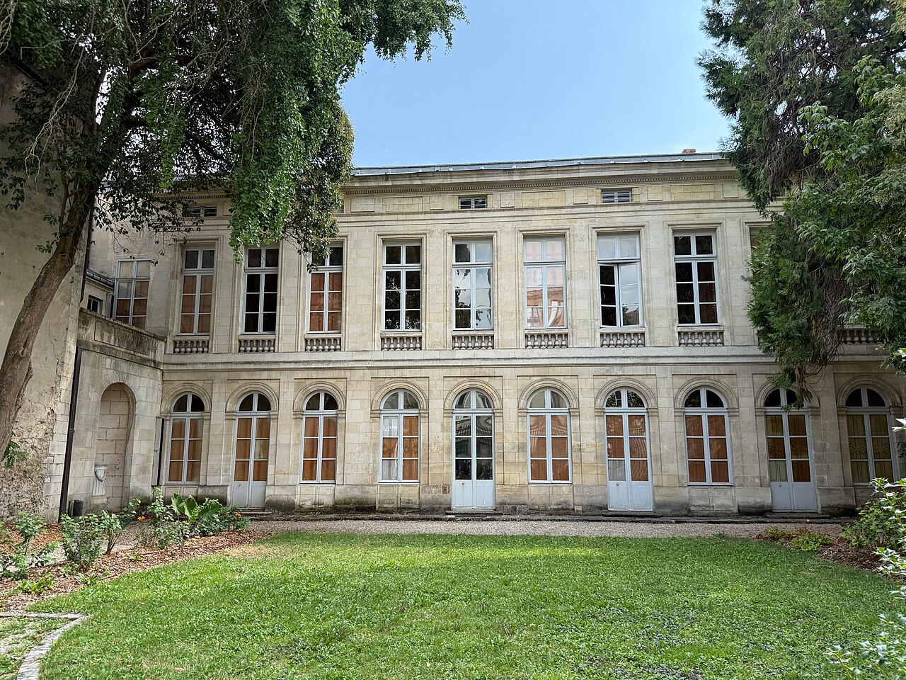 La façade classique sur jardin de l’hôtel Fleuriau, qui abrite le musée du Nouveau Monde à La Rochelle, derrière une pelouse et de grands arbres