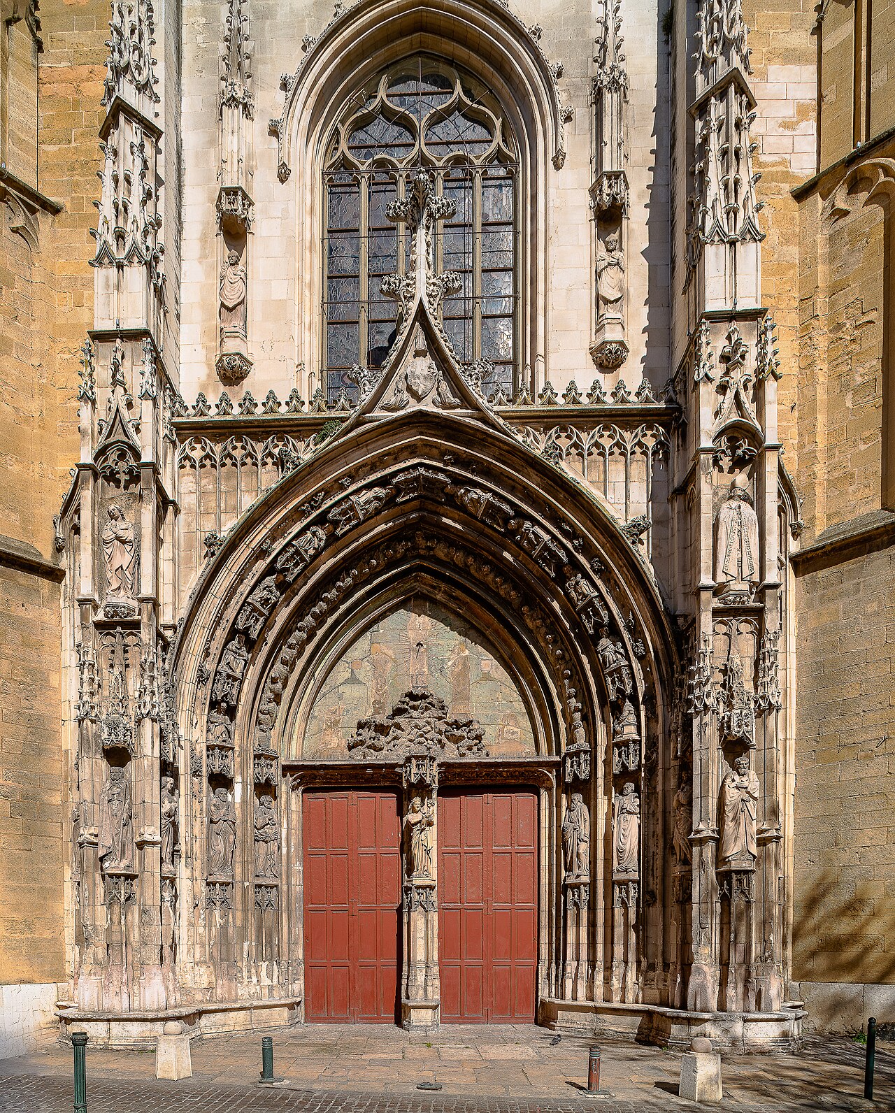 Le portail gothique flamboyant de la cathédrale Saint-Sauveur d’Aix-en-Provence, ses voussures sculptées, ses statues et ses vantaux peints en rouge