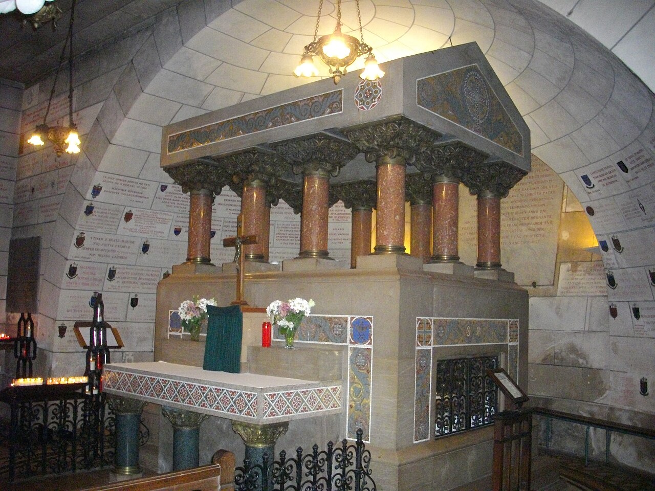 Le tombeau de saint Martin dans la crypte de la basilique de Tours, sous un baldaquin à colonnes de marbre rose, entouré de plaques d’ex-voto