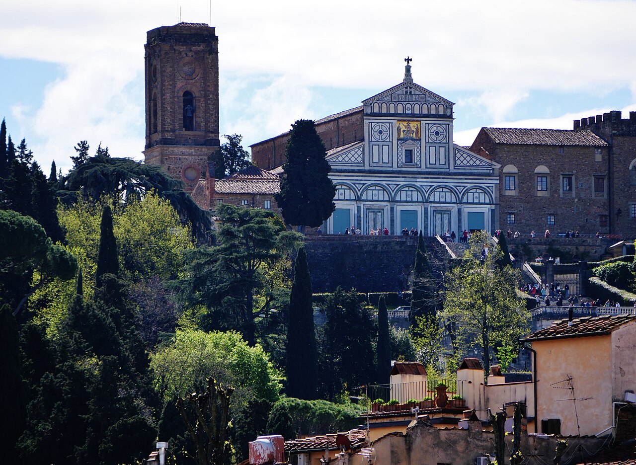 La basilique San Miniato al Monte sur sa colline : la façade de marbre blanc et vert, le campanile et le palais des évêques, au-dessus des cyprès