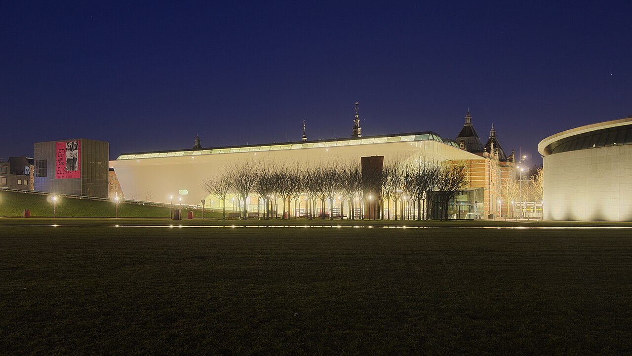 Le Stedelijk Museum de nuit, son aile blanche en forme de baignoire illuminée au bord du Museumplein
