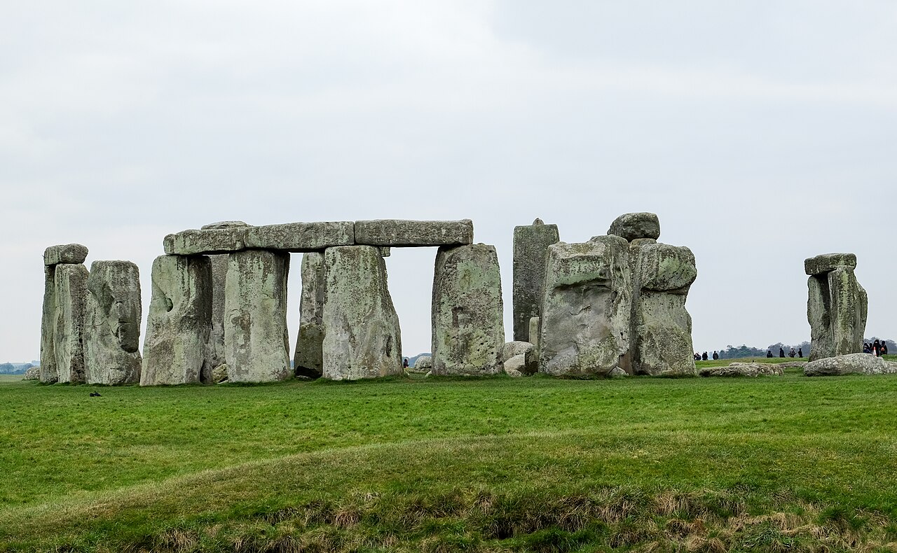 Le cercle de pierres dressées de Stonehenge sur la plaine herbeuse, sous un ciel gris